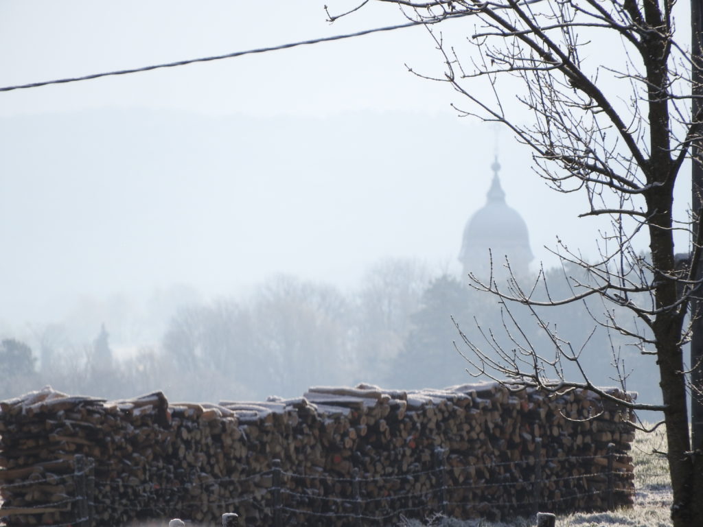 La silhouette du clocher de Bucey dans la brume matinale